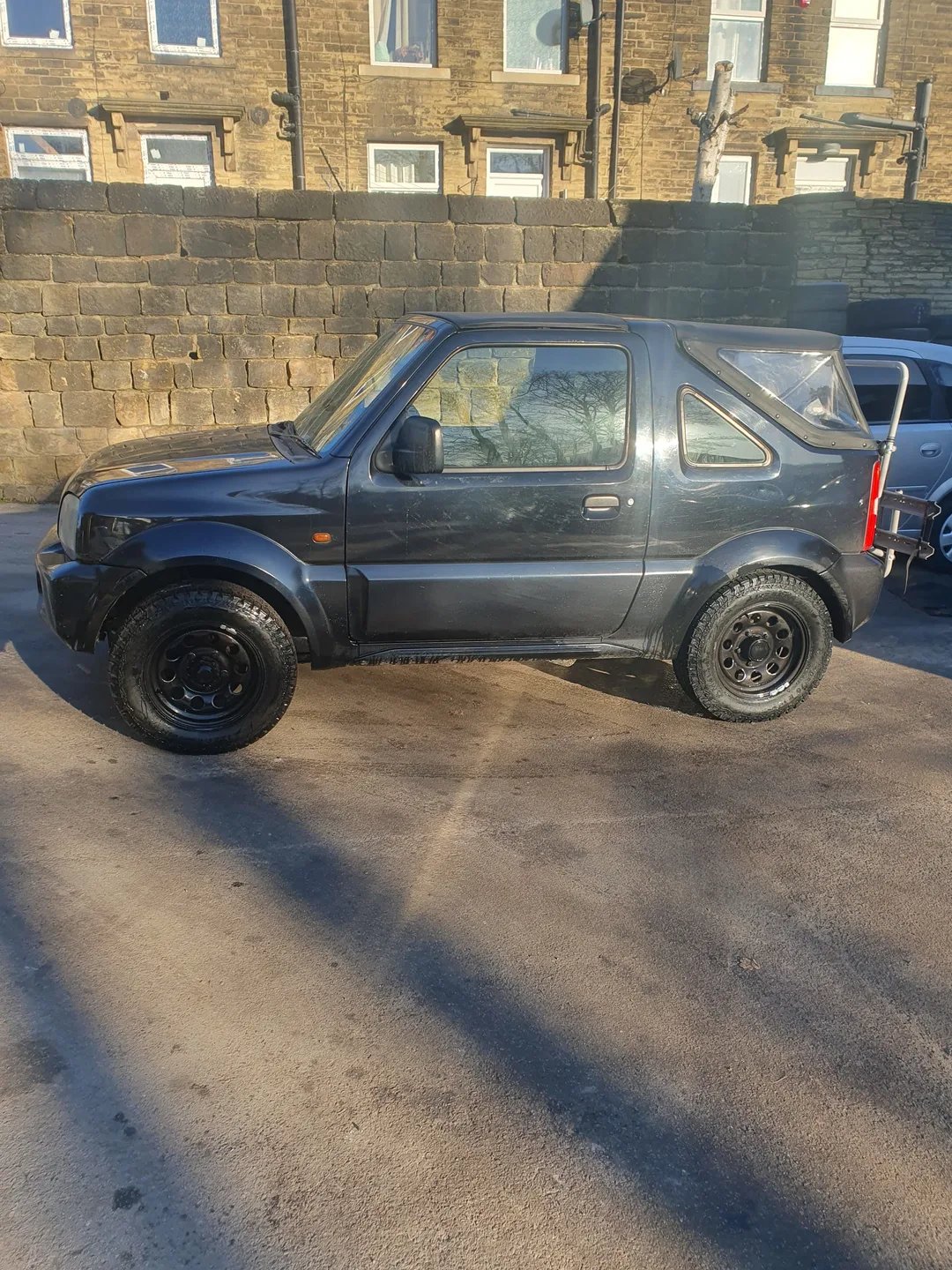 A compact four-wheel-drive vehicle outside the workshop