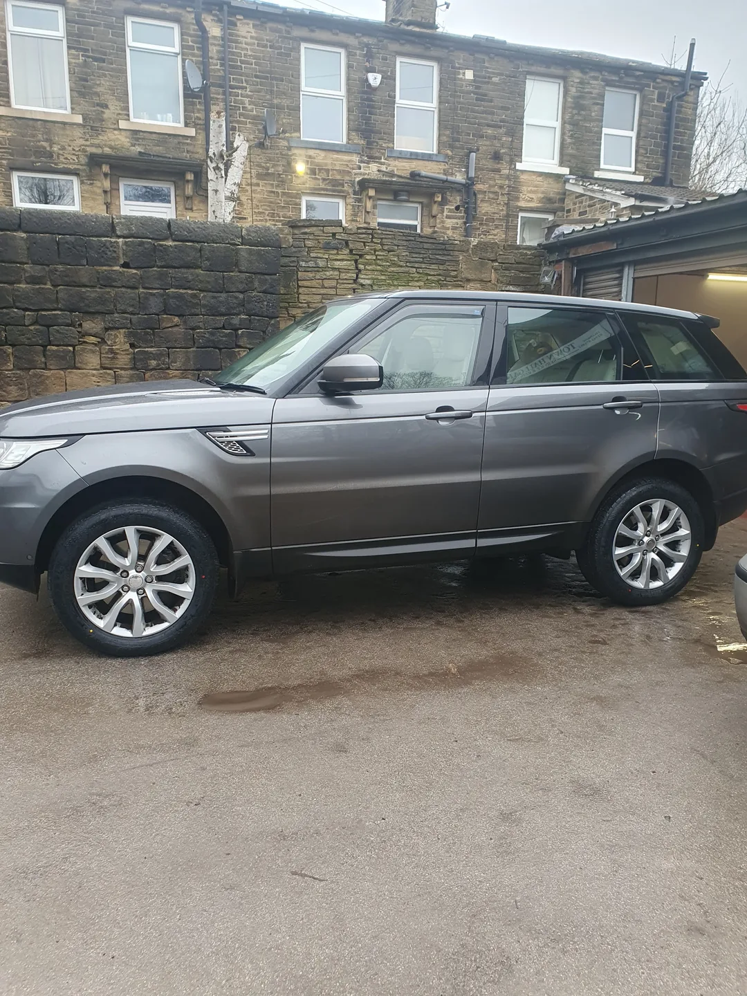 Silver SUV parked beside the workshop roller door